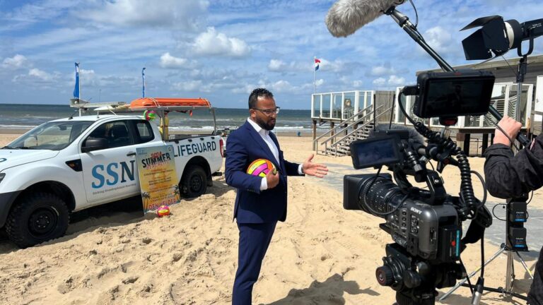 Wethouder Camara op het strand waar een interview wordt afgenomen voor het evenement Summer BeachLife