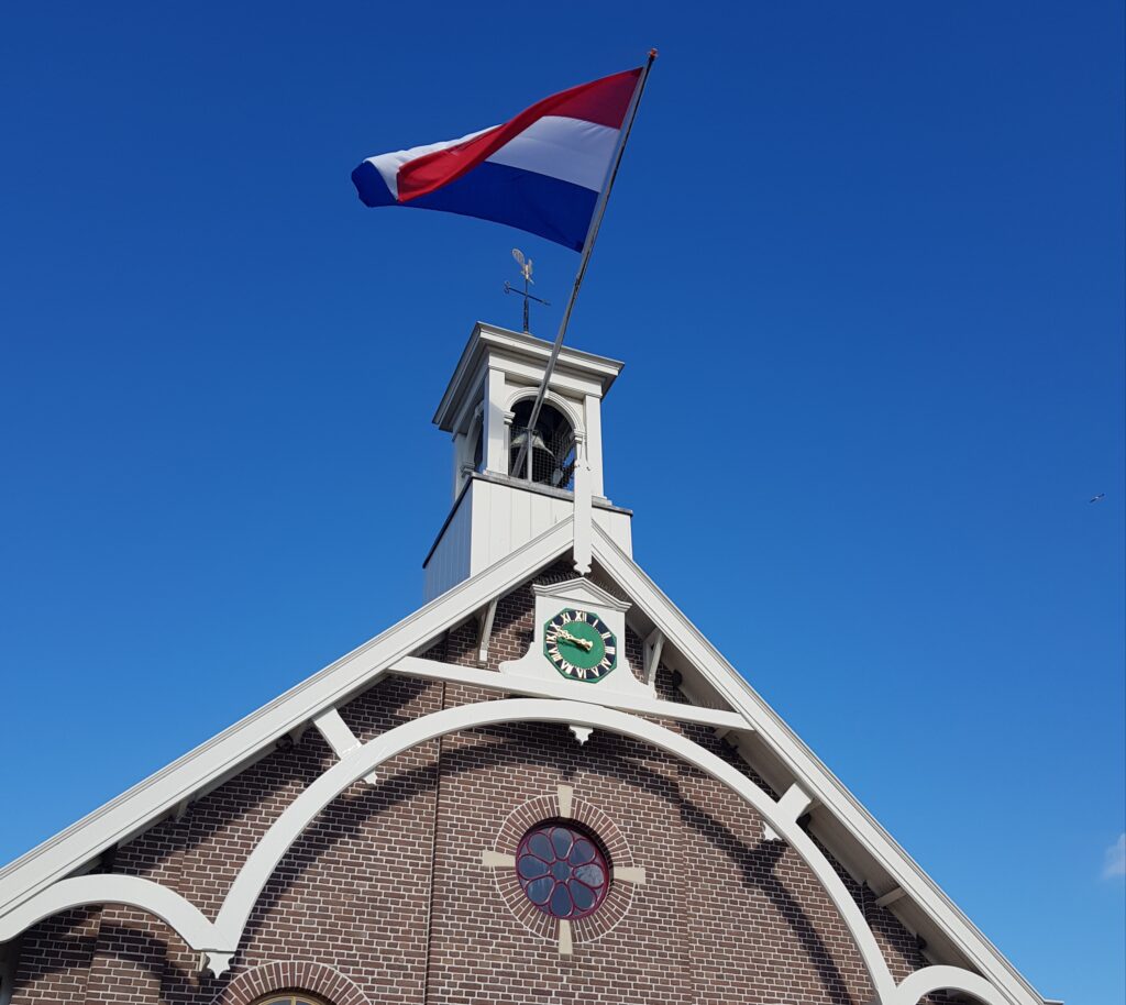 Huisduinerkerkje met de Nederlandse vlag die wappert