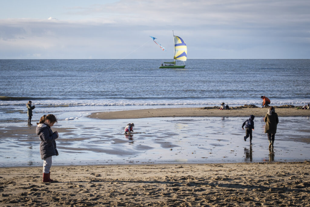Wandelaars op het strand in de winter