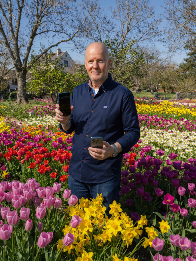 Fred van Eck tussen de bloemen voor de smartphoneworkshop