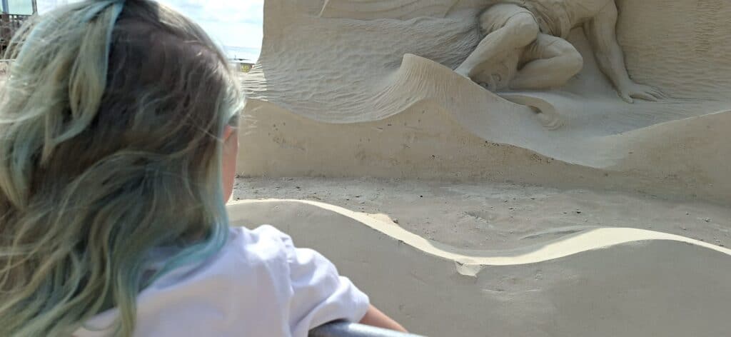 Linde kijkt naar de details in de Zandsculpturen